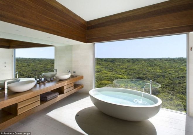 The Osprey Pavilion bathroom at Southern Ocean Lodge on Kangaroo Island has a hand sculptured granite bath placed in front of floor-to-ceiling windows