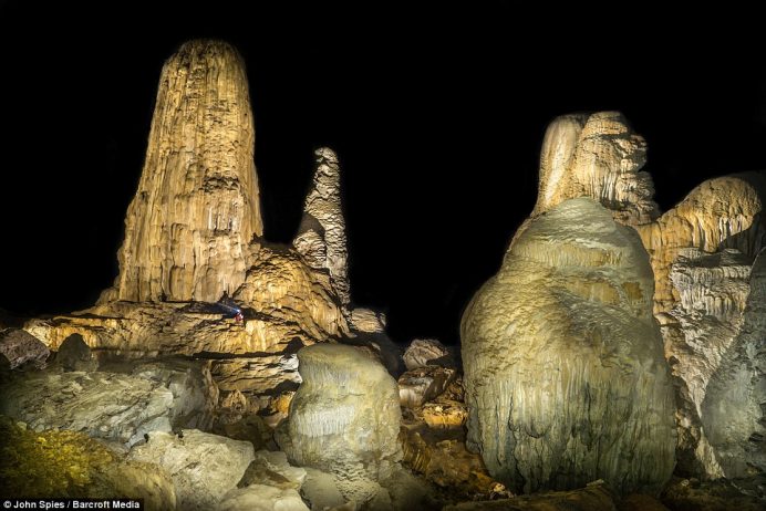 A cave explorer amongst giant stalagmites in the Stairway to Heaven area of the cave. The cave is formed by the Xe Bang Fai river, a major tributary of the Mekong