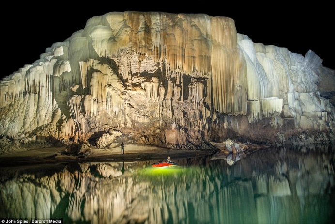 Enormous banks of terraced flowstone decorate the walls of the cave in many places. This slowly growing mound of white and orange calcite is one of the larger deposits along the river passage