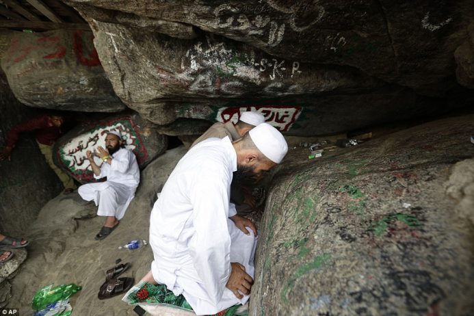 A Muslim pilgrim prays near rocks at the top of Noor Mountain, close to the entrance of Hira cave