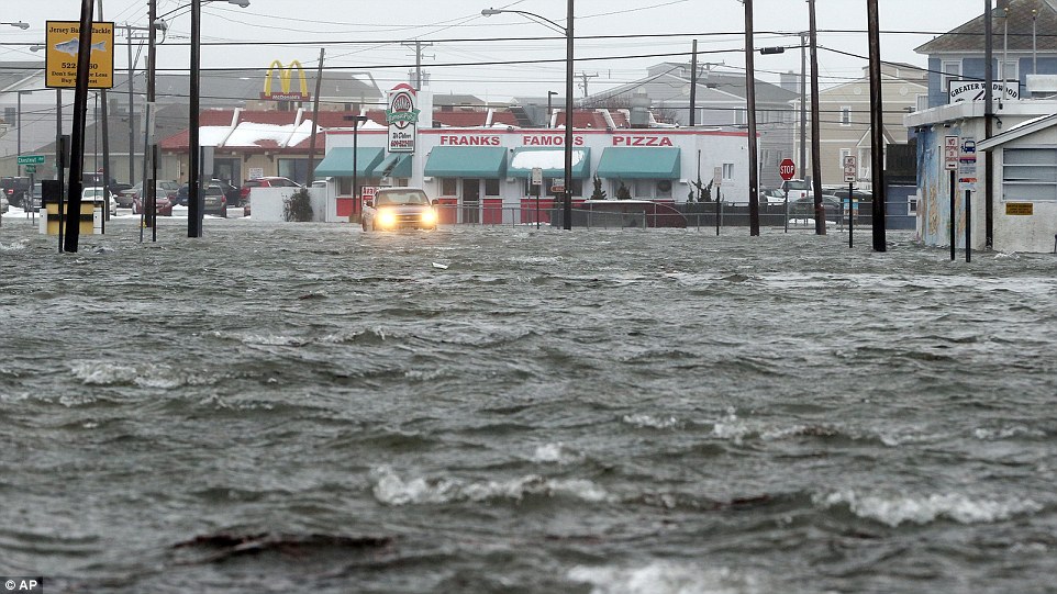 A car attempts to drive through the flooded streets of North Wildwood, New Jersey, on Saturday
