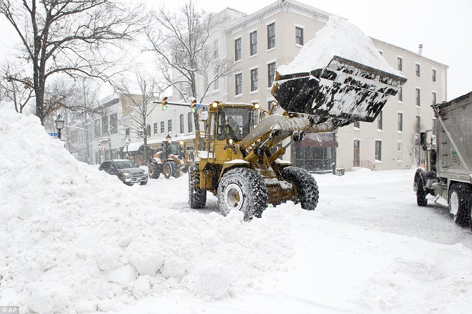 A digger loads snow into a dumper truck in Alexandria, Virginia, on Saturday amid heavy snowfall which caused traffic accidents across the state