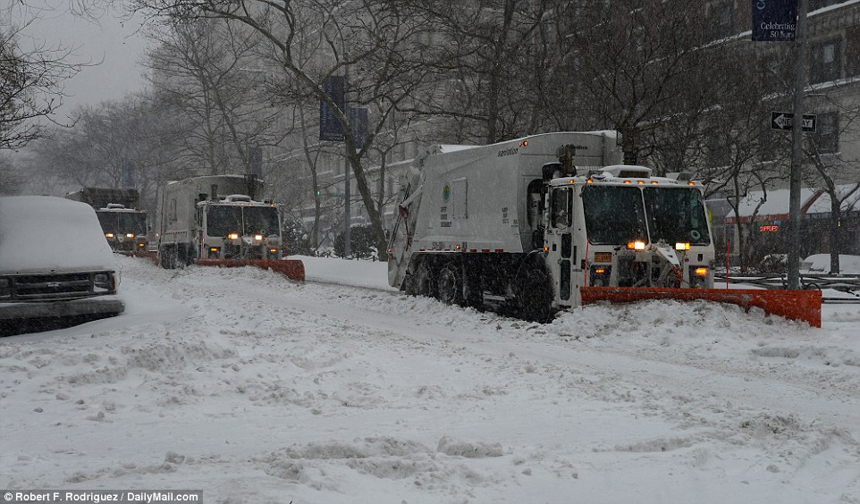 A trio of snowplows attempts to clear snow from Broadway on the Upper West Side in New York on Saturday as snow continues overnight