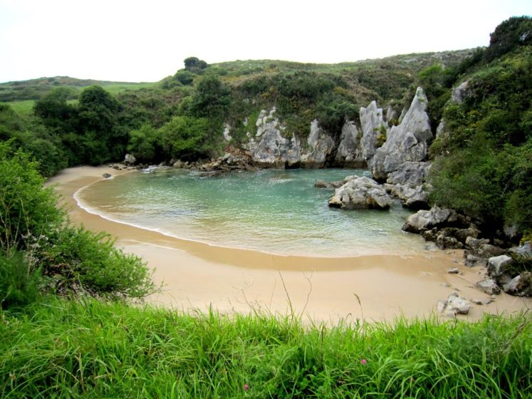 A tunnel beneath the rocks channels water from the Cantabrian Sea into a cove, beach is off the A8 road between Santander and Oviedo.