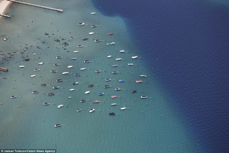 Small boats in the summer can be seen moored off Lake Tahoe, which is located in the Sierra Nevada Mountains in California