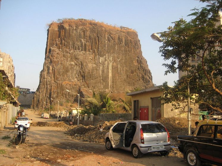 These vertical columns are akin to the Devils Tower in Wyoming, and the Devils Postpile in eastern California, the USA due to similarities in its sheer rock face and basalt-rock composition.
